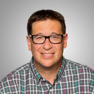 Photo of Scott Pansky wearing a plaid button down shirt and glasses